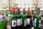 Aktionswoche Alkohol: Das Bild zeigt leere Weinflaschen auf einem Altglascontainer