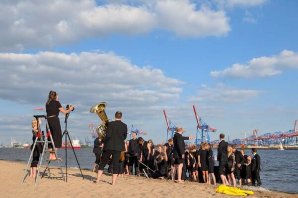 Junge Philharmoniker beim Fotoshooting am Elbstrand bei der Strandperle. Symbol für ein spannendes Wochenende in Hamburg