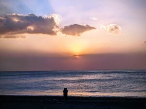 Ein Paar im Sonnentuntergang am Strand - Symbolbild für stressfreies Reisen und Urlaubsplanung